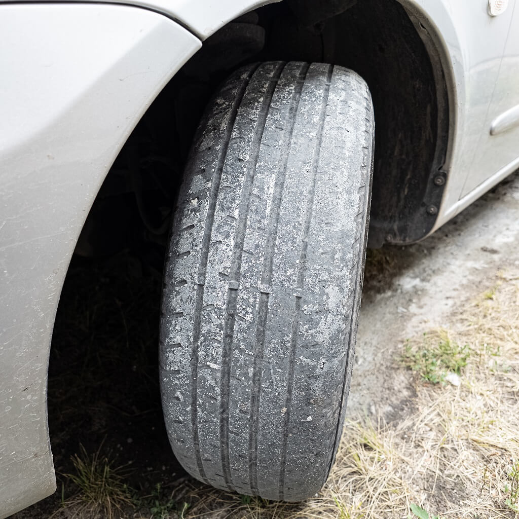 Istrošena auto guma sa skoro potpuno izgubljenom šarom